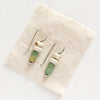 The turquoise and lemon chrysoprase lobe hugger earrings styled on tan linen