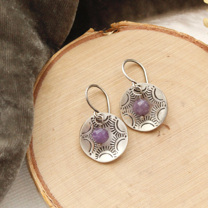 The lepidolite jolie cupped earrings styled on wood with gray velvet