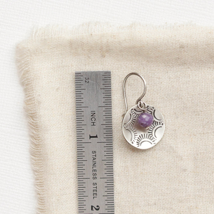 A lepidolite jolie cupped earring next to a ruler for size reference