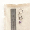 A lepidolite jolie earring next to a ruler for size reference