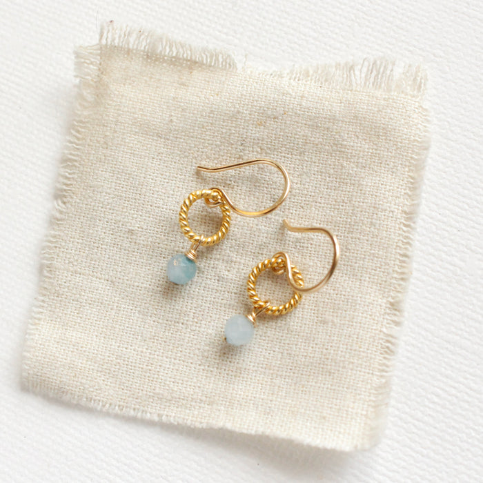 The little aquamarine gold hoop earrings styled on tan linen