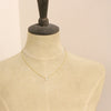 A mannequin wearing the little opal drop necklace