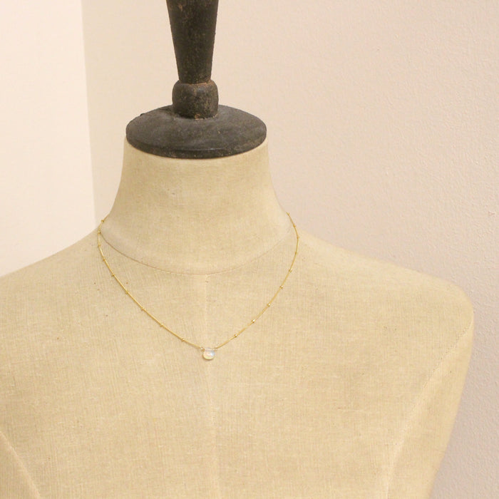 A mannequin wearing the little opal drop necklace