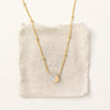 The little opal drop necklace styled on tan linen