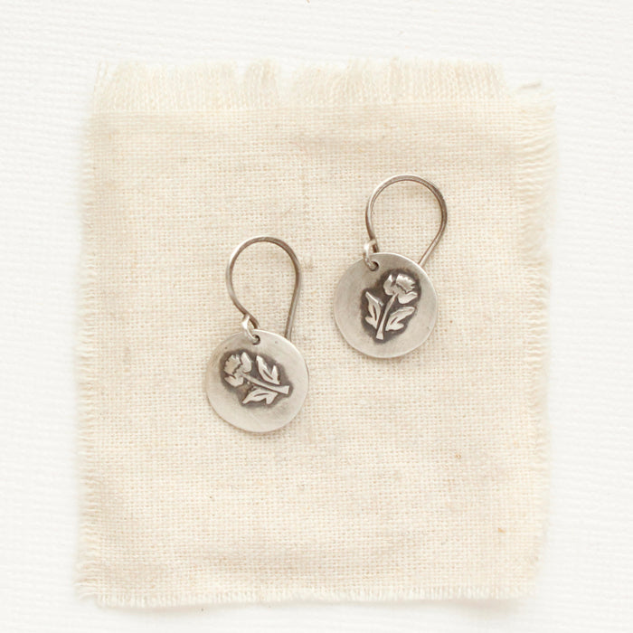 The little rustic rose earrings styled on tan linen