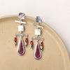 The maximalist purple spiny oyster post earrings styled on a tan plate