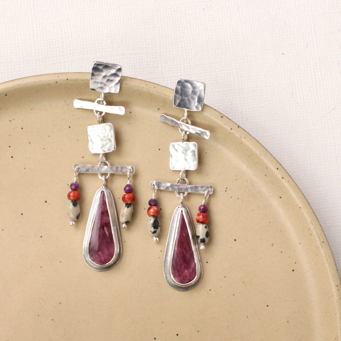 The maximalist purple spiny oyster post earrings styled on a tan plate