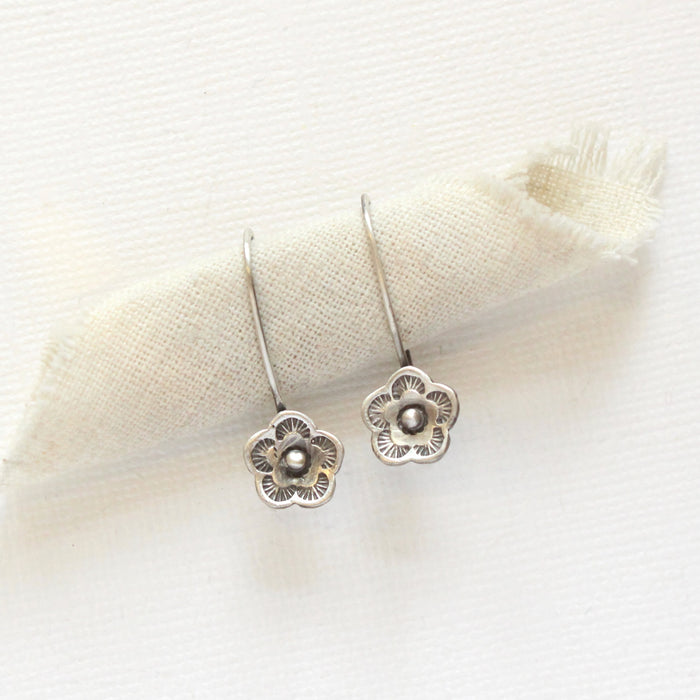 The mini cactus flower lobe hugger earrings styled on rolled linen