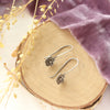 The mini cactus flower lobe hugger earrings styled on wood with purple velvet and dried grass