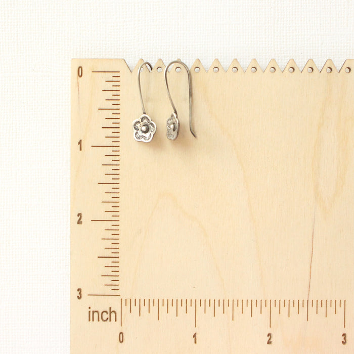 The mini cactus flower lobe hugger earrings on a wooden ruler for size reference