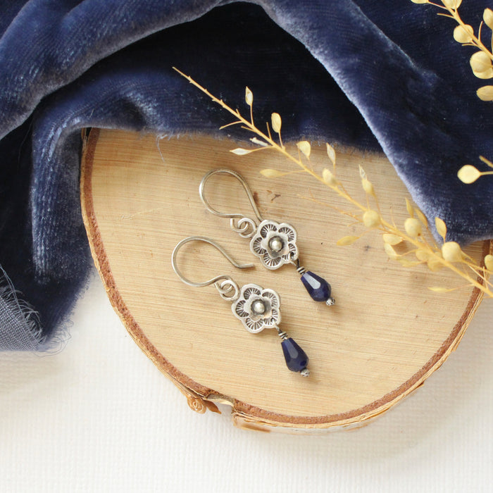 The mini cactus flower sodalite lantern earrings styled on wood with blue velvet and dried grass