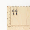 The mini cactus flower sodalite lantern earrings on a wooden ruler for size reference