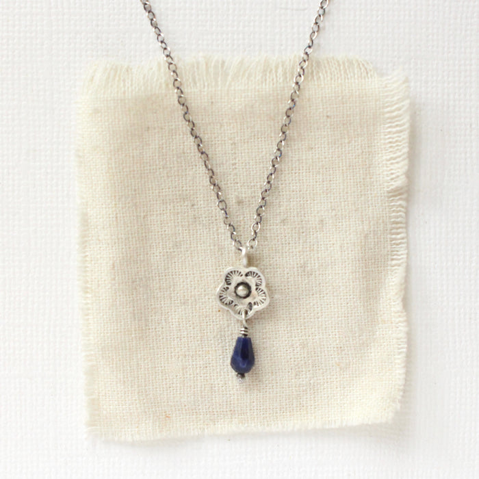 The mini cactus flower sodalite lantern necklace styled on tan linen
