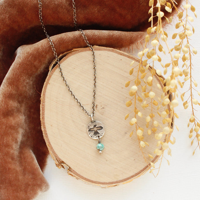 The mini soar and turquoise necklace styled on wood with orange velvet and dried grass
