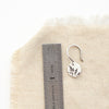 A mini sprout earring next to a ruler for size reference