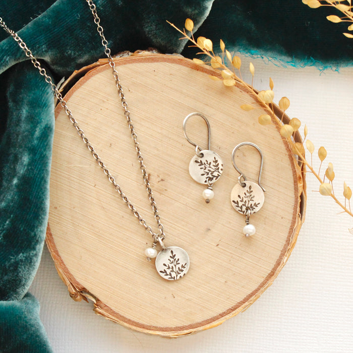 The mini sprout pearl dangle earrings styled on wood with the matching necklace and blue velvet