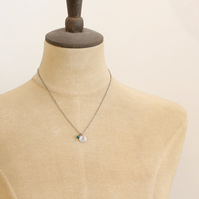 A mannequin wearing the mini sprout turquoise charm necklace