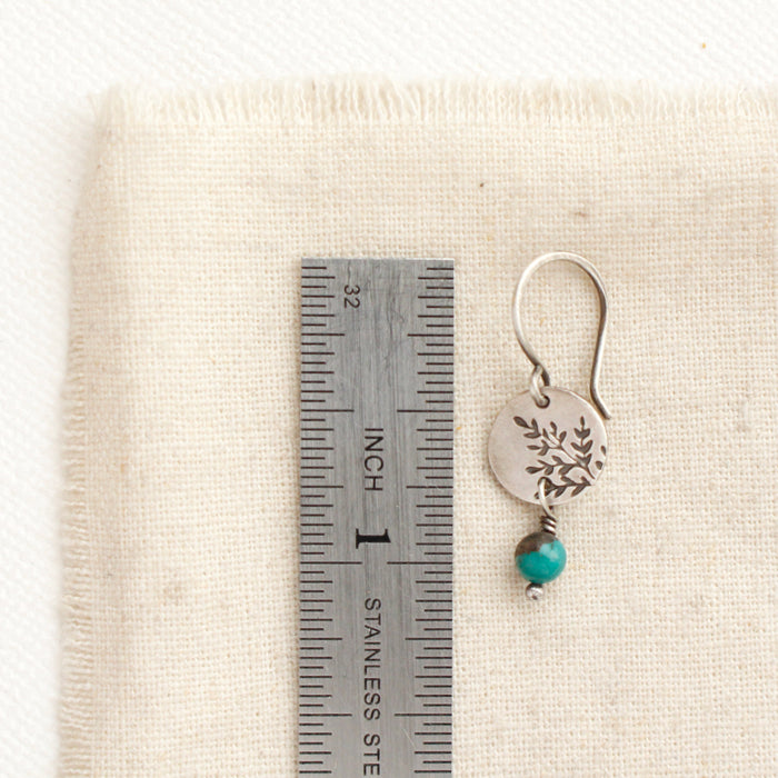 A mini sprout turquoise dangle earring next to a ruler for size reference