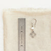 A mini talara pearl earring next to a ruler for size reference
