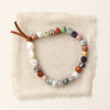 The mixed gem, pearl, and leather stretch bracelet styled on tan linen