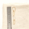 A mixed metal paperclip earring next to a ruler for size reference