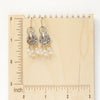 The vienna earrings on a wooden ruler for size reference 