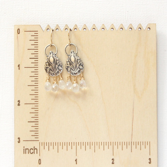 The vienna earrings on a wooden ruler for size reference 
