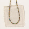 The mixed opal necklace styled on tan linen
