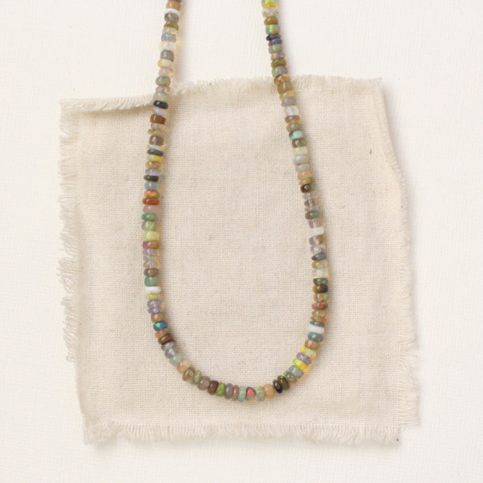 The mixed opal necklace styled on tan linen