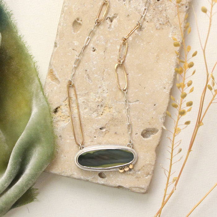 The modern imperial jasper necklace styled on a tan rock with green velvet and dried grass