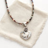 The mohave white buffalo turquoise heart and succulent necklace with the mixed gemstone chain option styled on tan linen