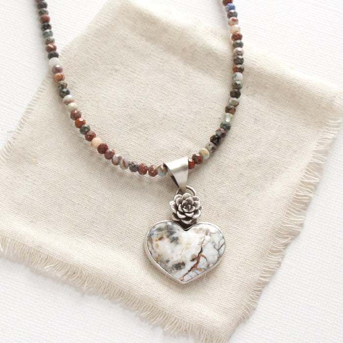 The mohave white buffalo turquoise heart and succulent necklace with the mixed gemstone chain option styled on tan linen