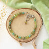 The monica bracelet styled on wood with green velvet and dried grass