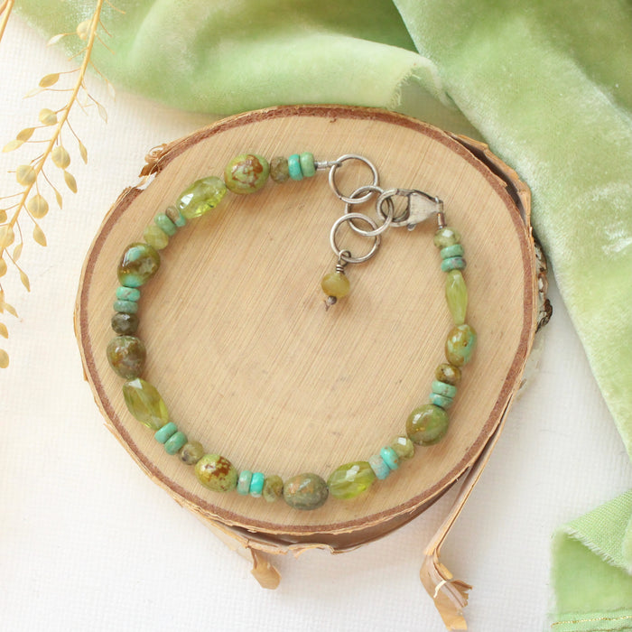 The monica bracelet styled on wood with green velvet and dried grass
