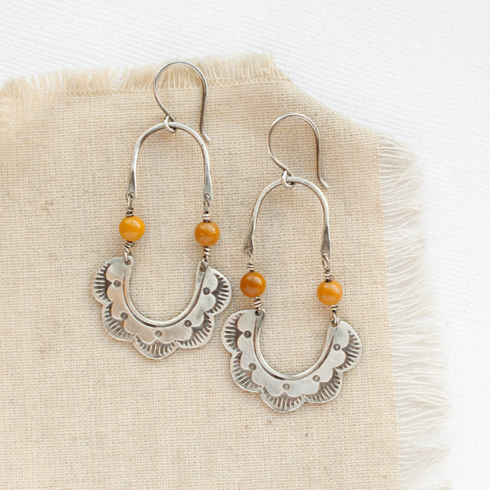 The mookaite columbine hoop earrings styled on tan linen