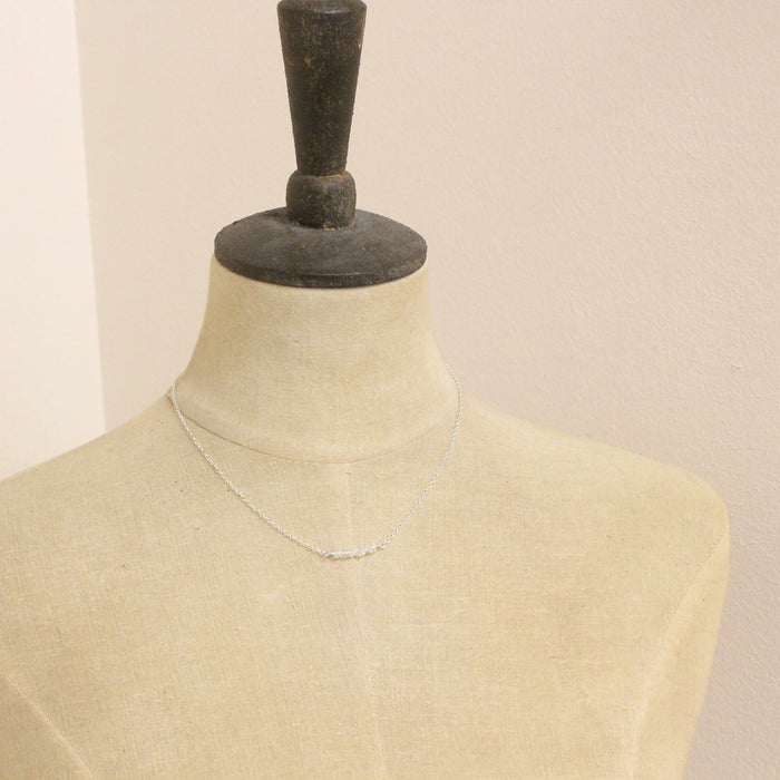 A mannequin wearing the opal bar necklace