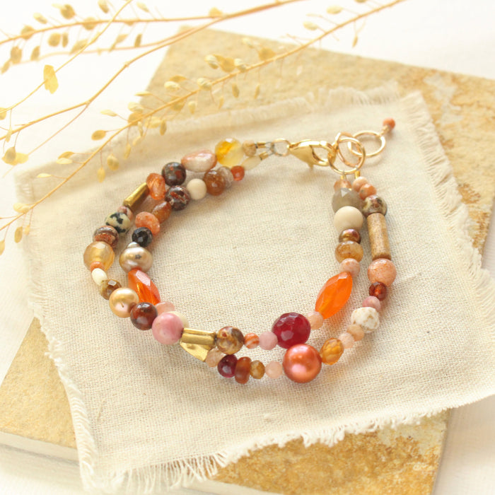 The orange crush bracelet styled on a tan rock with dried grass