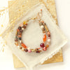 The orange crush bracelet styled on a tan rock with linen and dried grass