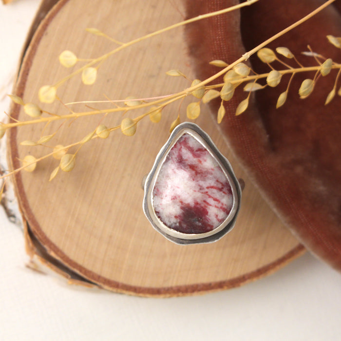 The organic thulite and little ruby ring styled on wood with orange velvet and dried grass