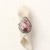 The organic thulite and little ruby ring styled on rolled tan linen