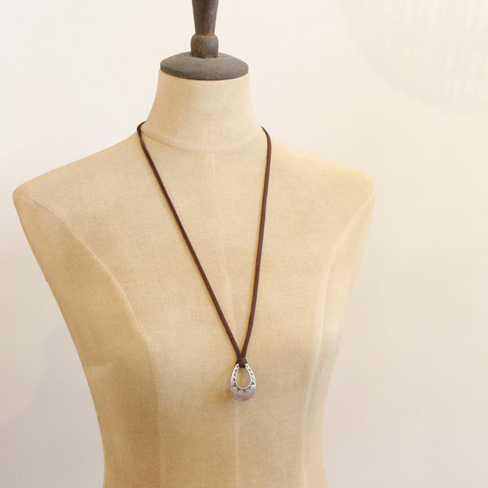 A mannequin wearing the pakal teardrop adjustable leather necklace in the longer style