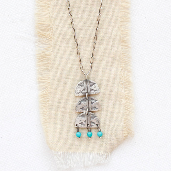 The pakal trio turquoise dangle necklace styled on tan linen