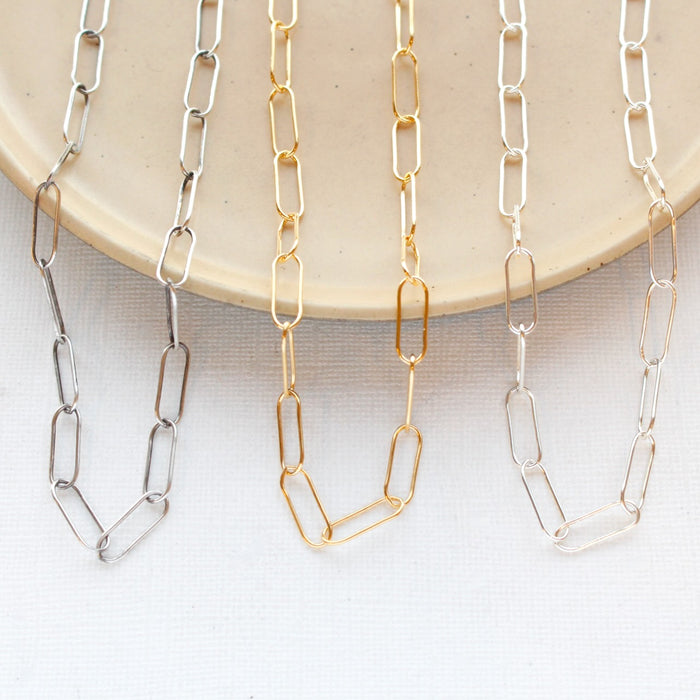 All three options of the paperclip necklaces styled on a tan plate