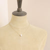A mannequin wearing the carved pearl skull necklace