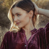 The pearl wrapped oxidized silver vine earrings being worn by a model
