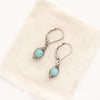 The wrapped amazonite earrings styled on tan linen
