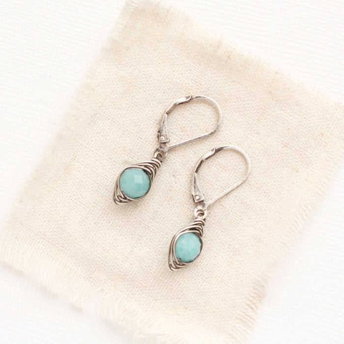 The wrapped amazonite earrings styled on tan linen