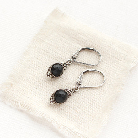 The perfect wrapped onyx earrings styled on tan linen