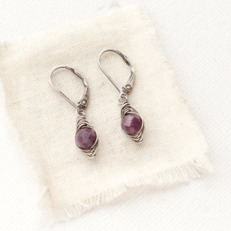 The perfect wrap purple ruby earrings styled on tan linen