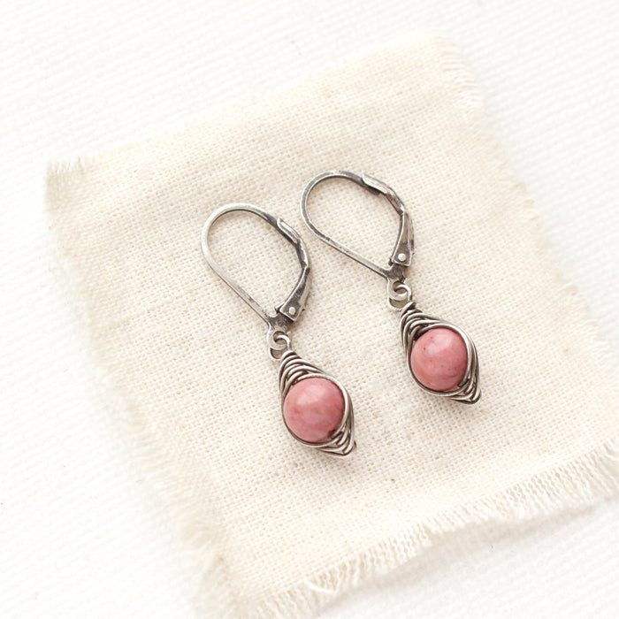 The perfect wrap rhodonite earrings are styled on tan linen